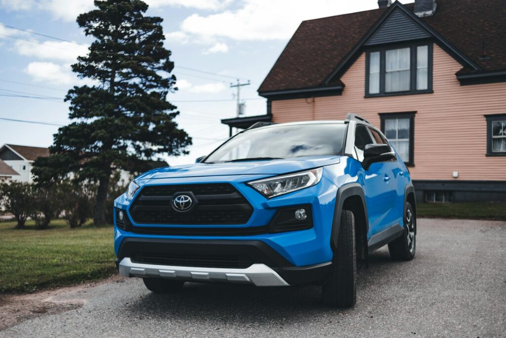 Blue Toyota SUV parked outside a house, showcasing modern automotive design in a suburban setting. Best Cell Phone Holder for Toyota Rav4.